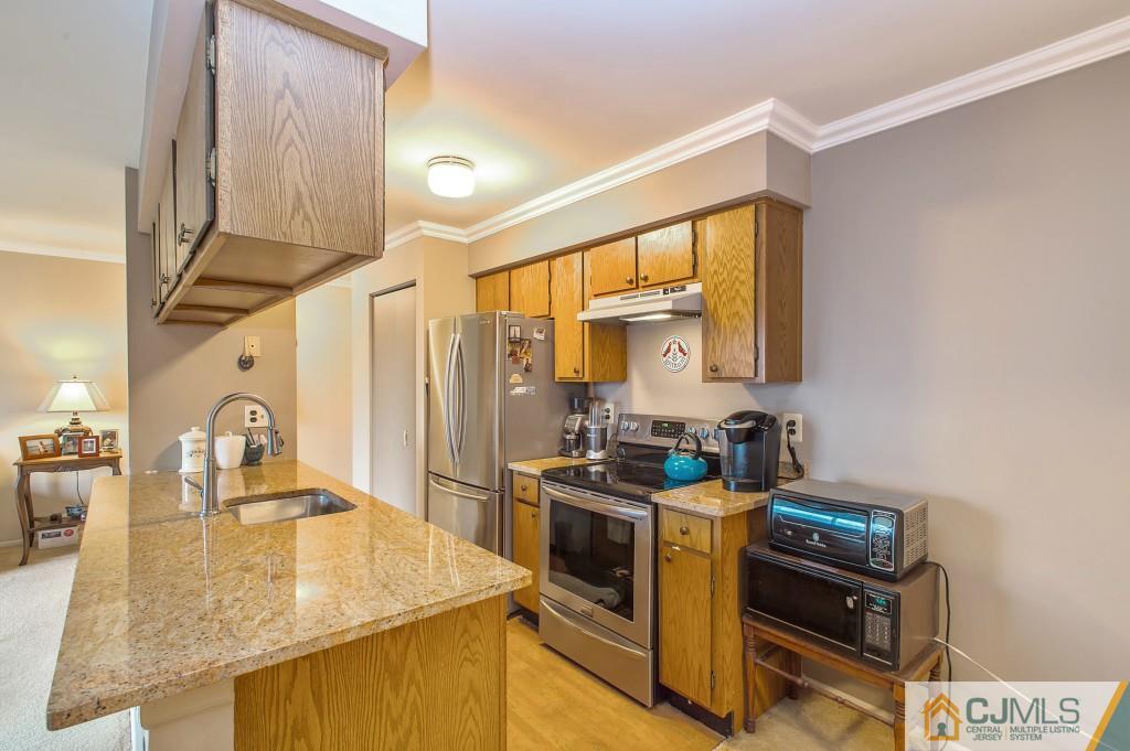 52 Bolton Court Somerset, NJ 08873 - Photo 7 of 18 a kitchen with stainless steel appliances granite countertop a stove a sink and a refrigerator