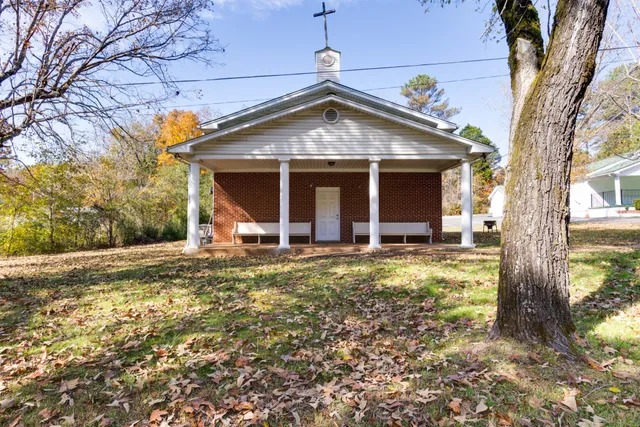 a view of a house with backyard and trees