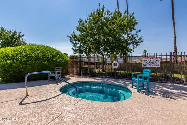 a backyard of a house with table and chairs under an umbrella