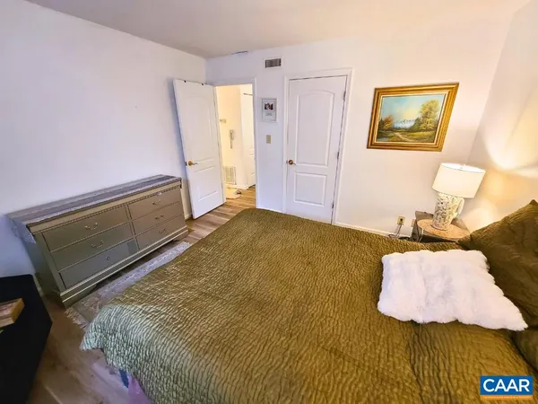 a bedroom with a bed and wooden floor