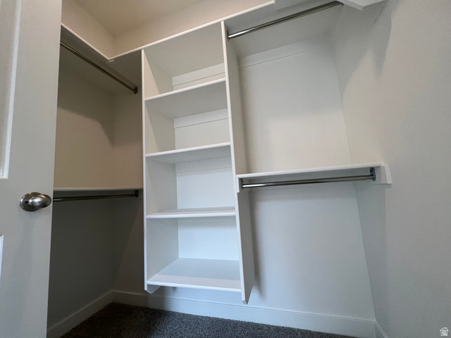 717 West W Coho Lane South, Unit 2F302 Midvale, UT 84047 - Photo 22 of 22 Walk-in closet featuring white built-in shelving, multiple hanging rods, and dark gray carpet flooring
