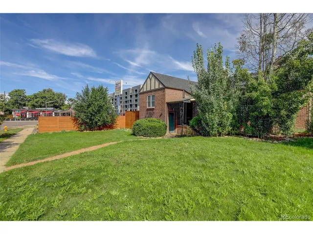 a view of a house with a yard and a tree