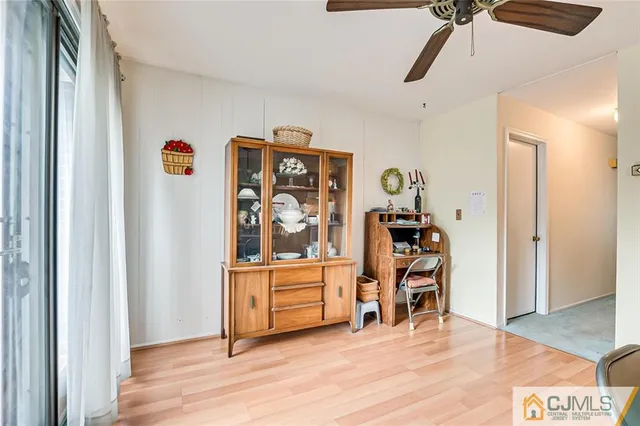 a view of a bedroom with baby bed and workspace