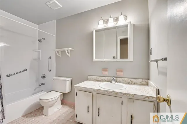 a bathroom with a granite countertop toilet a sink and a mirror