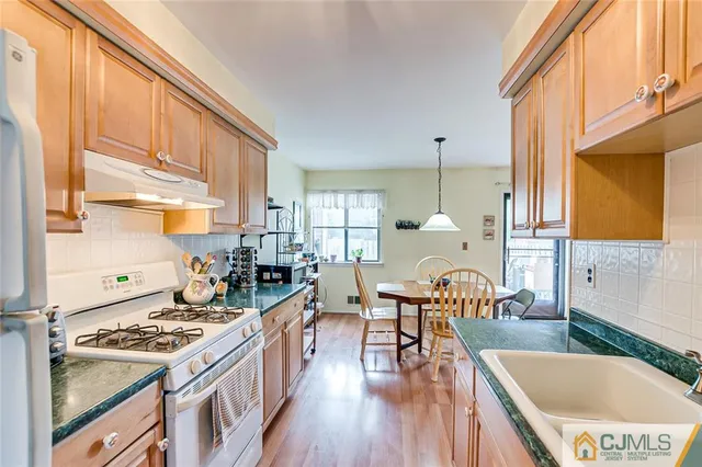 a kitchen with a table chairs stove and wooden floor
