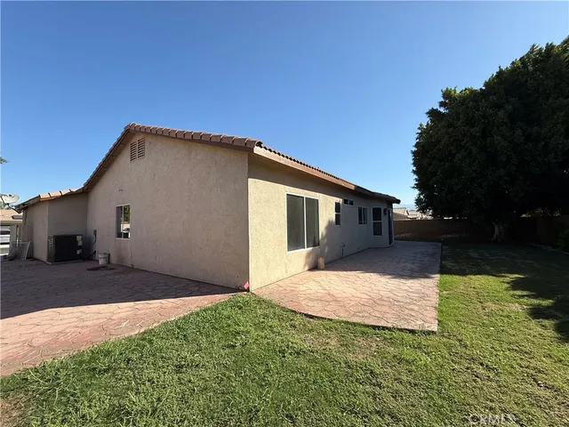 a front view of house with yard and trees in the background