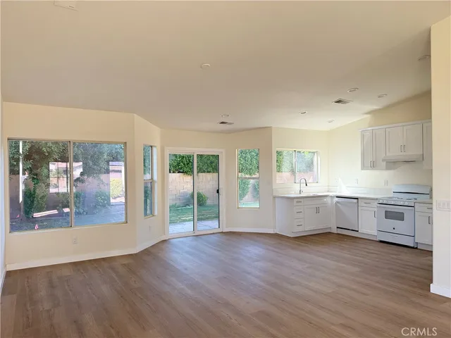 a kitchen with stainless steel appliances wooden floors and white cabinets