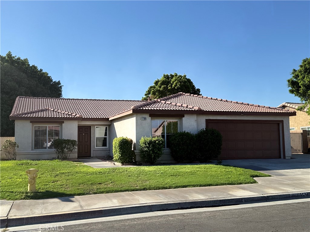 47686 Mirage Way Indio, CA 92201 - Photo 3 of 23 a front view of a house with a garden