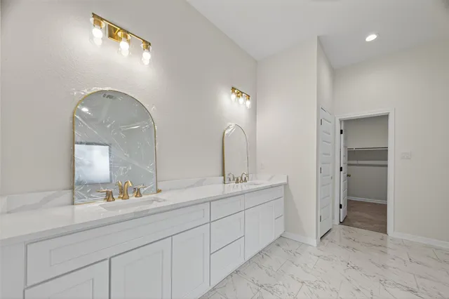 a spacious bathroom with a double vanity sink and a mirror