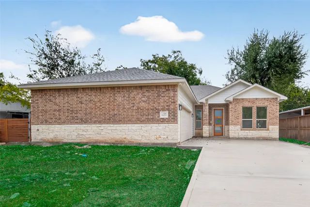 a front view of a house with a garden and yard