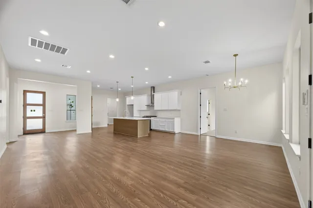 a view of a kitchen with wooden floor and a window