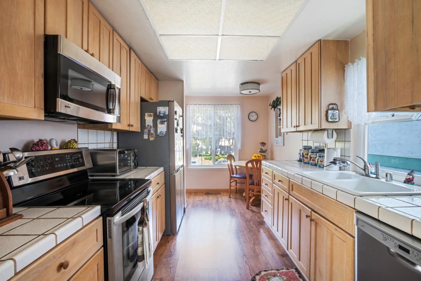 1128 Oddstad Boulevard Pacifica, CA 94044 - Photo 7 of 35 a kitchen with stainless steel appliances a stove sink microwave and cabinets