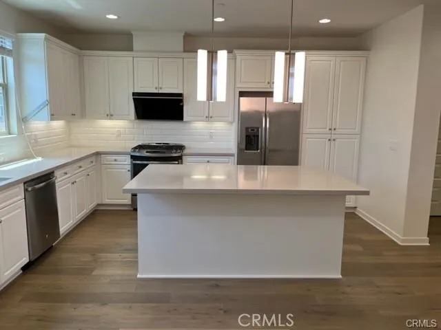 a kitchen with stainless steel appliances granite countertop a stove a sink and a refrigerator