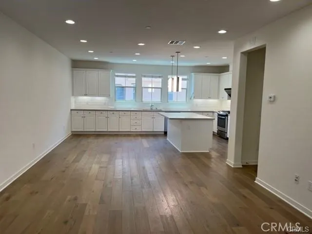 a kitchen with a wooden floor and white cabinets