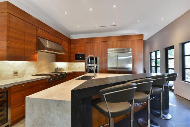a kitchen with stainless steel appliances granite countertop a sink a stove a table and chairs