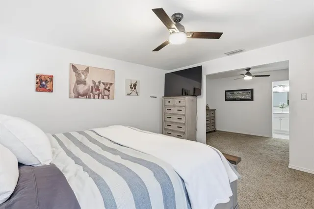 a bedroom with a large bed and a ceiling fan