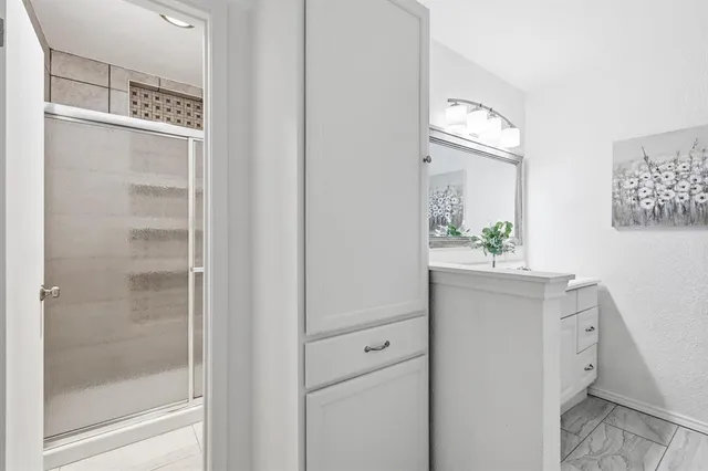 a bathroom with a shower sink and mirror