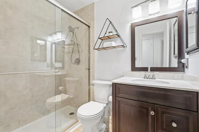 a bathroom with a granite countertop sink toilet and shower