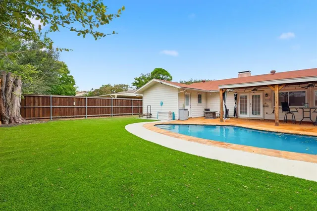 a view of a house with a swimming pool and a yard