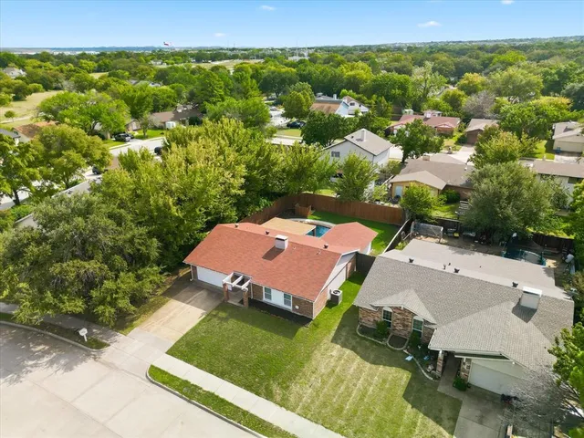an aerial view of a house with garden space and street view