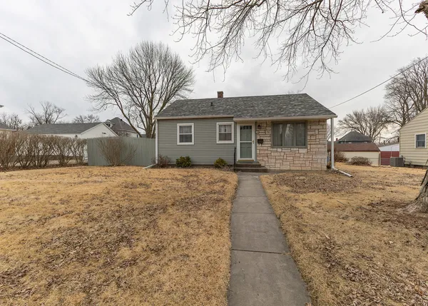 a front view of house with yard covered in snow