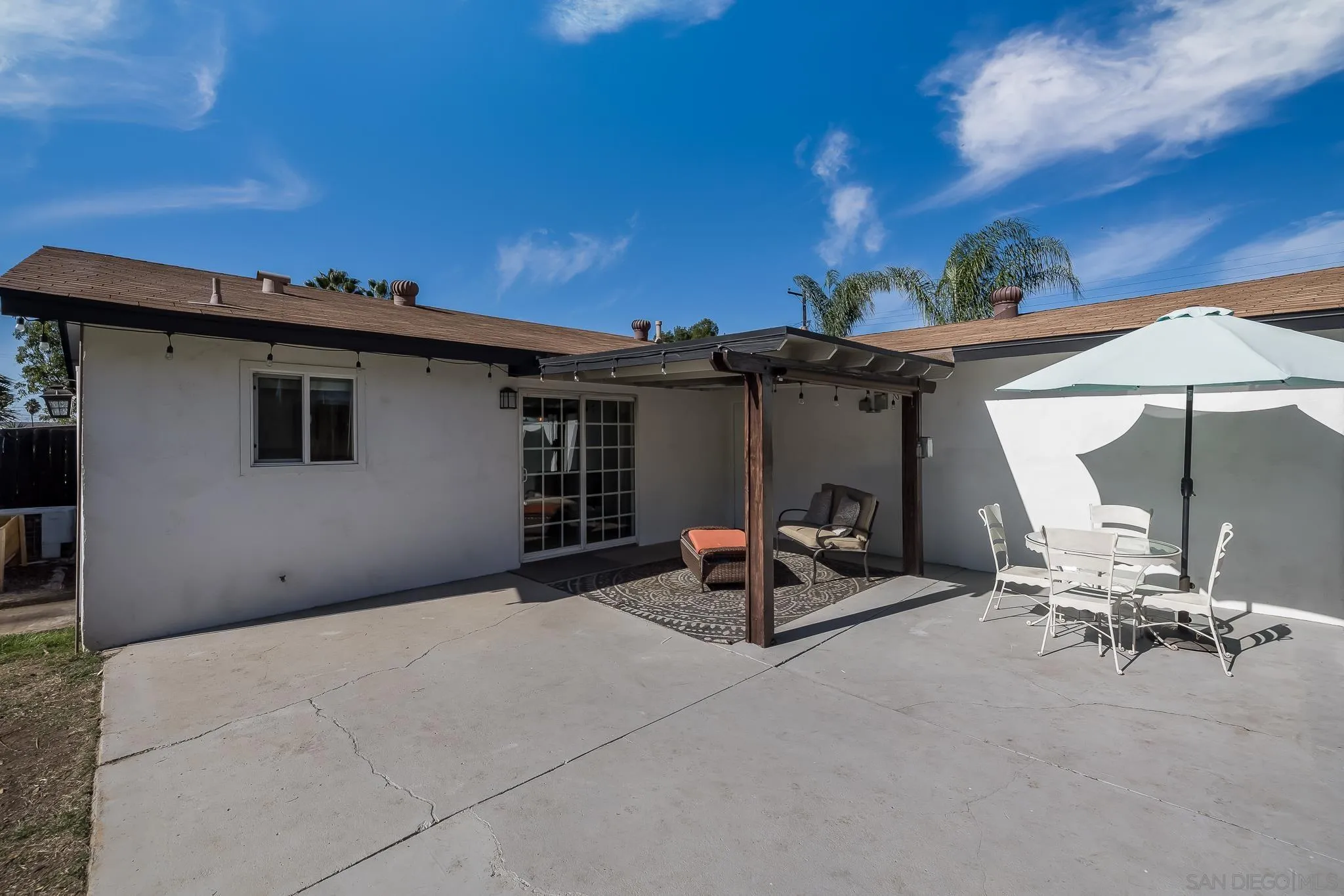 9126 Heatherdale Street Santee, CA 92071 - Photo 21 of 33 a view of a patio with a table and chairs under an umbrella