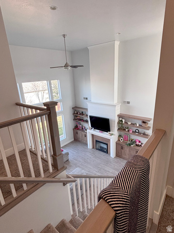 429 East Treasure Road Washington, UT 84780 - Photo 34 of 36 Stairs featuring a ceiling fan, a fireplace, and wood finished floors