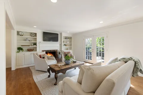 a living room with furniture a flat screen tv and a fireplace