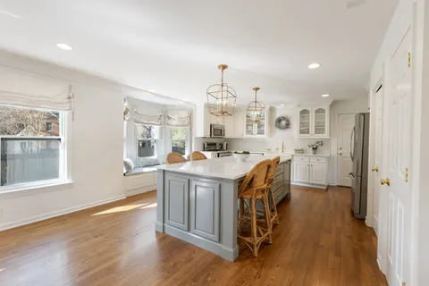 a kitchen with a sink stove and wooden floor