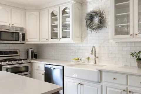 a kitchen with granite countertop a sink stainless steel appliances and cabinets