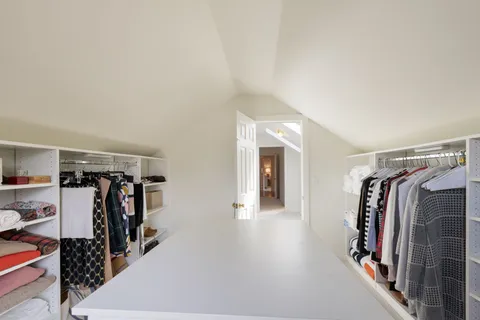 a view of walk in closet with clothes and shoes