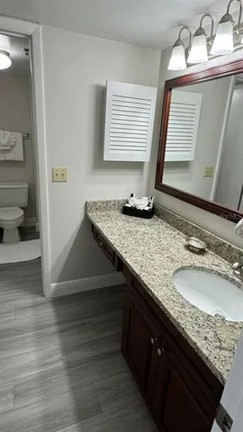 a bathroom with a granite countertop sink and a mirror