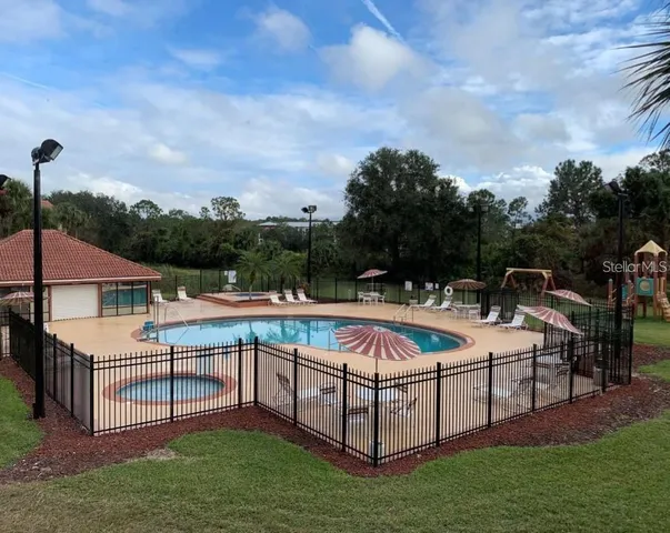 a view of a patio with swimming pool and sitting area