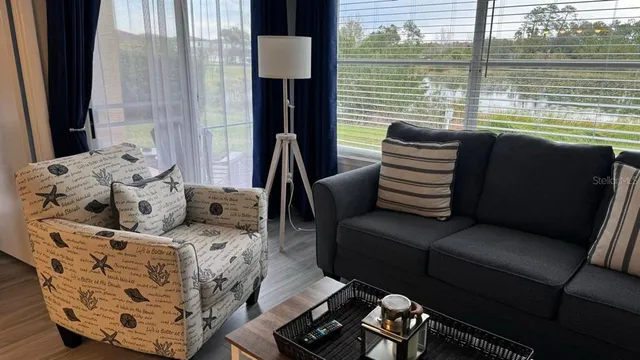 a bedroom with furniture and a large window