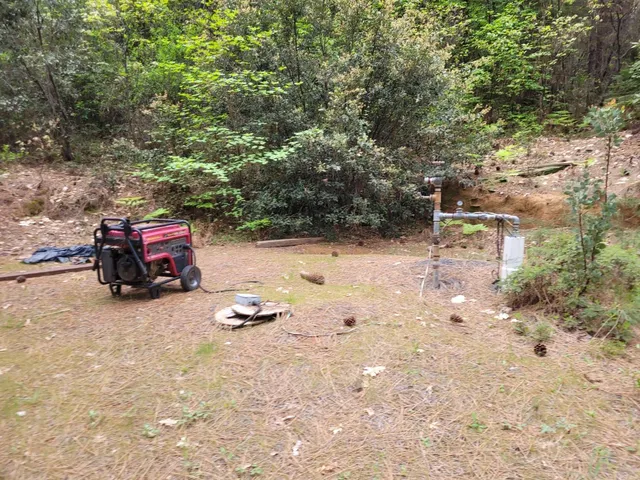 a backyard of a house with fire pit and trees