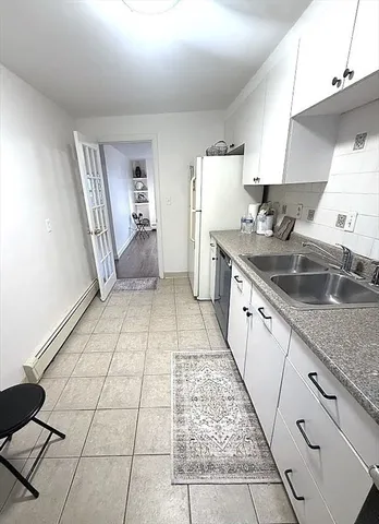 a kitchen with a sink a refrigerator and cabinets