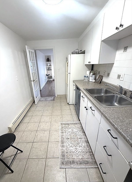 105 Chestnut Street, Unit 2 Brookline, MA 02445 - Photo 4 of 7 a kitchen with a sink a refrigerator and cabinets