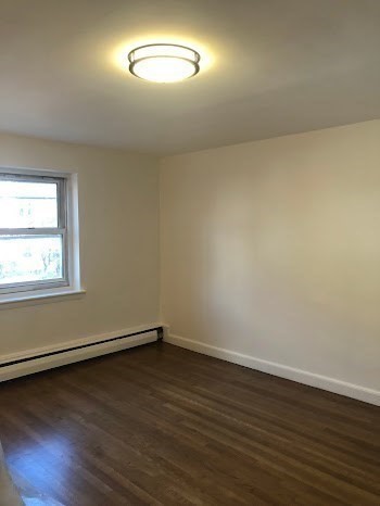 105 Chestnut Street, Unit 2 Brookline, MA 02445 - Photo 7 of 7 an empty room with wooden floor and windows