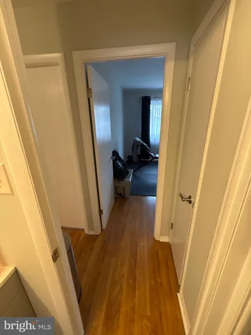 a view of a hallway with wooden floor and stairs
