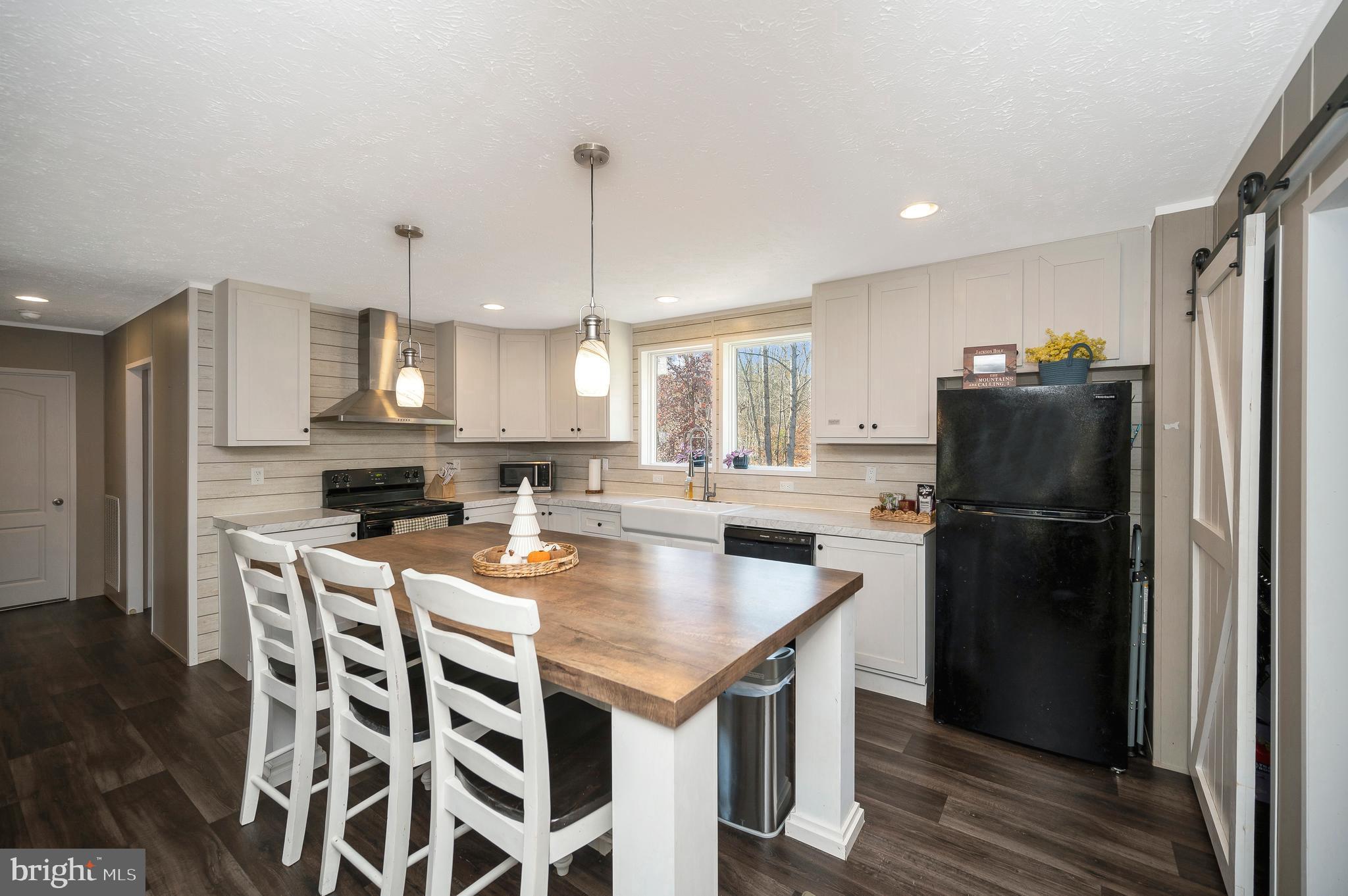 5120 Burr Hill Road Rhoadesville, VA 22542 - Photo 12 of 45 a kitchen with a refrigerator a stove a sink dishwasher with a dining table and chairs