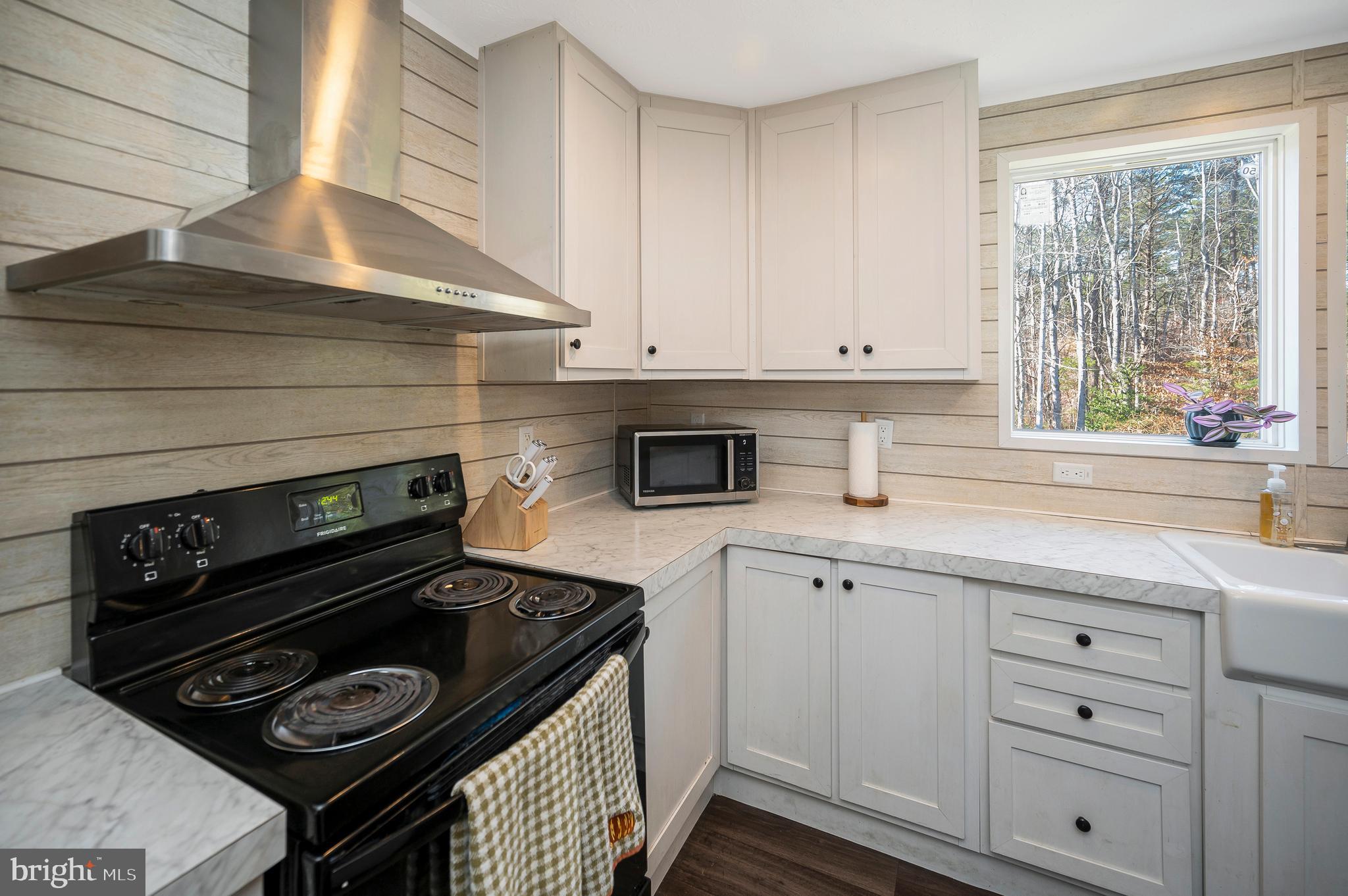5120 Burr Hill Road Rhoadesville, VA 22542 - Photo 16 of 45 a kitchen with white cabinets appliances and a window