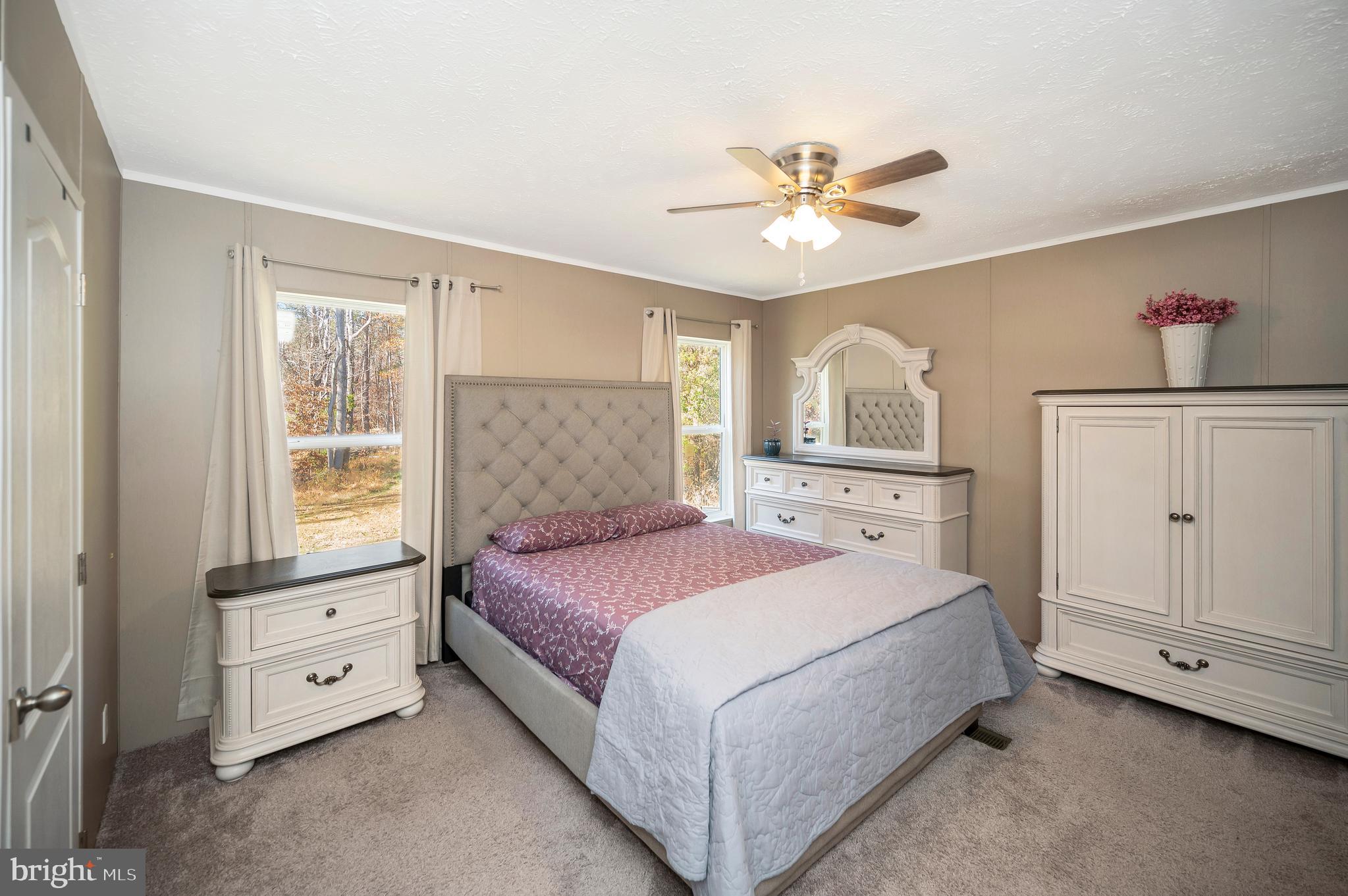 5120 Burr Hill Road Rhoadesville, VA 22542 - Photo 20 of 45 a spacious bedroom with a large bed and a chandelier