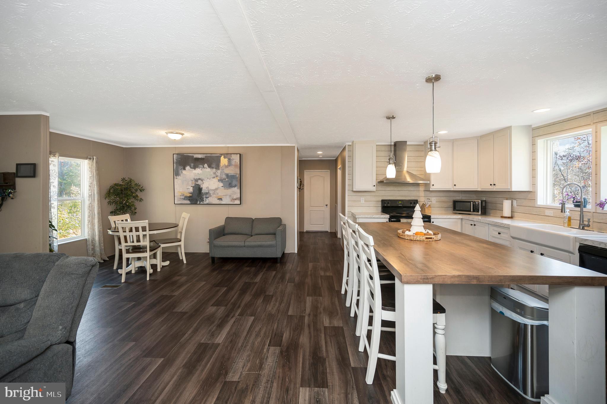 5120 Burr Hill Road Rhoadesville, VA 22542 - Photo 7 of 45 a open kitchen with stainless steel appliances granite countertop a stove a refrigerator a kitchen island a dining table and chairs with wooden floor