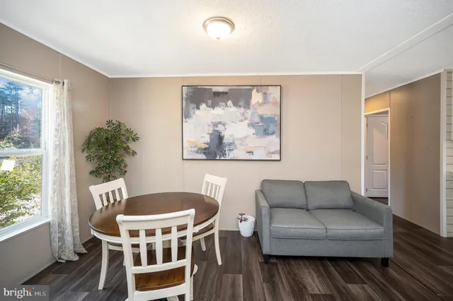 a living room with furniture a table and a painting next to a window