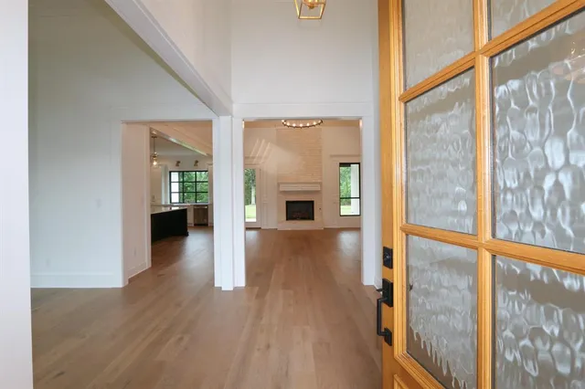 a view of a hallway with wooden floor fireplace and windows