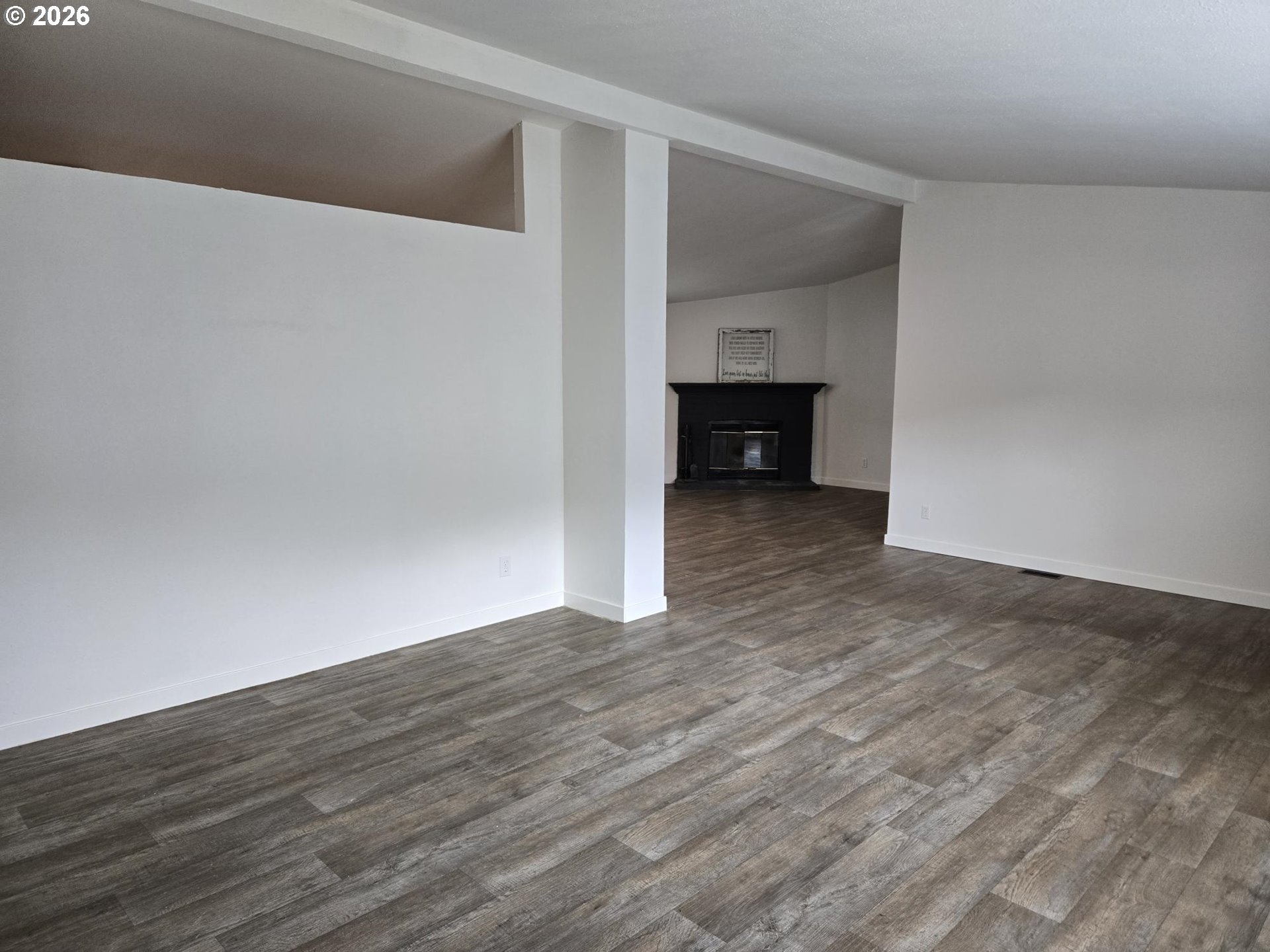 550 South State Street Sutherlin, OR 97479 - Photo 5 of 10 a view of an empty room with wooden floor and a fireplace