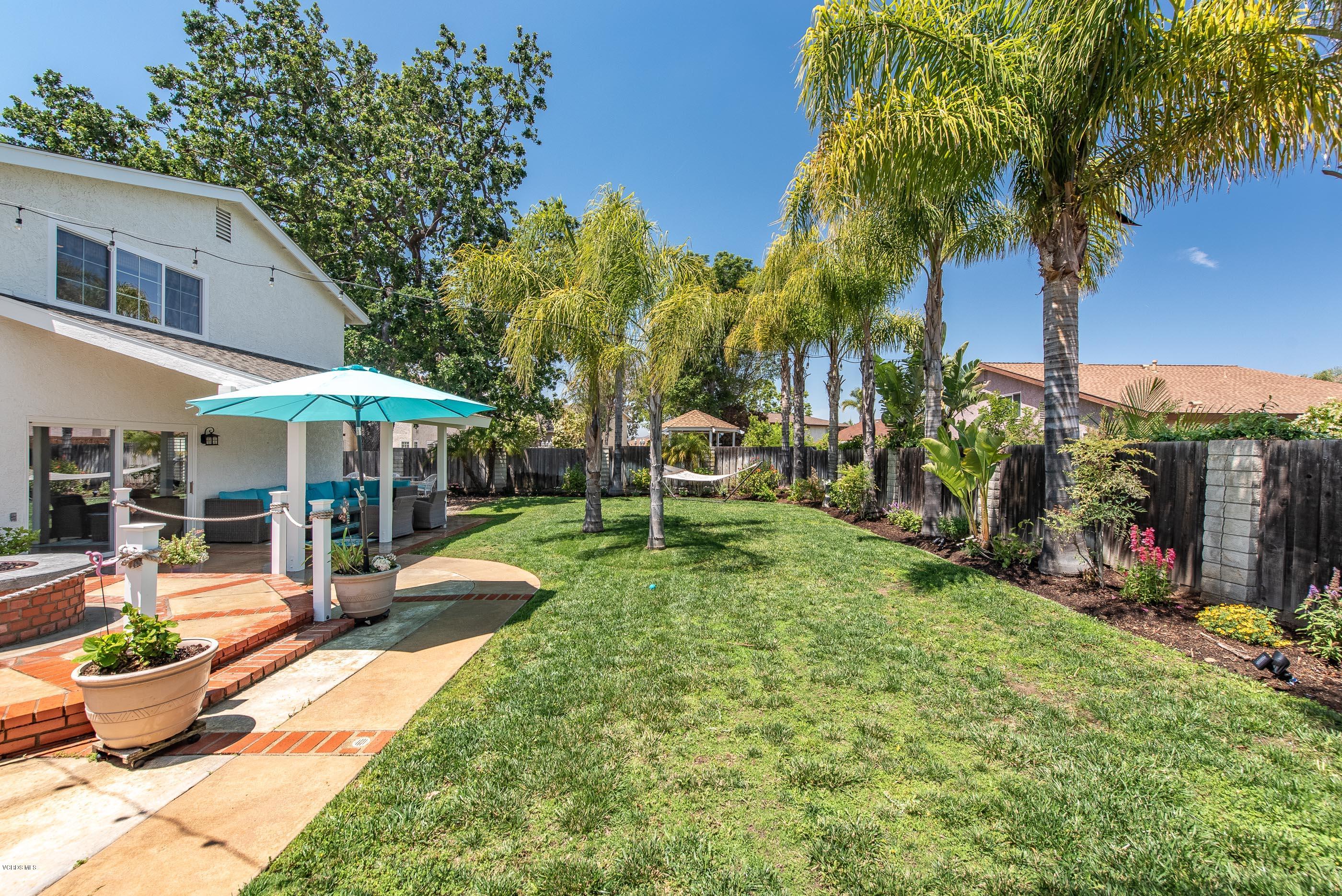 665 Azalea Street Thousand Oaks, CA 91360 - Photo 29 of 52 a view of a backyard with table and chairs under an umbrella