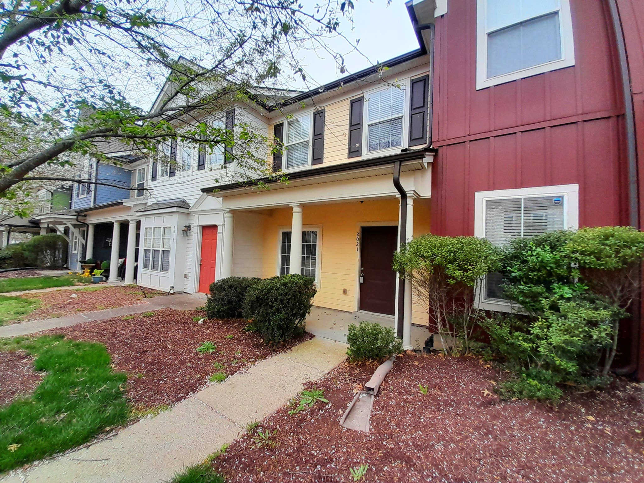 a front view of a house with garden and parking