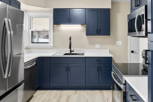 a kitchen with stainless steel appliances granite countertop a refrigerator and a sink