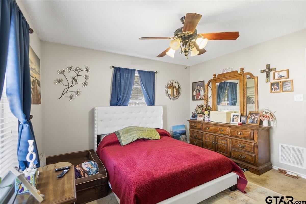 14716 Fox Ridge Tyler, TX 75709 - Photo 13 of 25 a bedroom with a bed and a chandelier